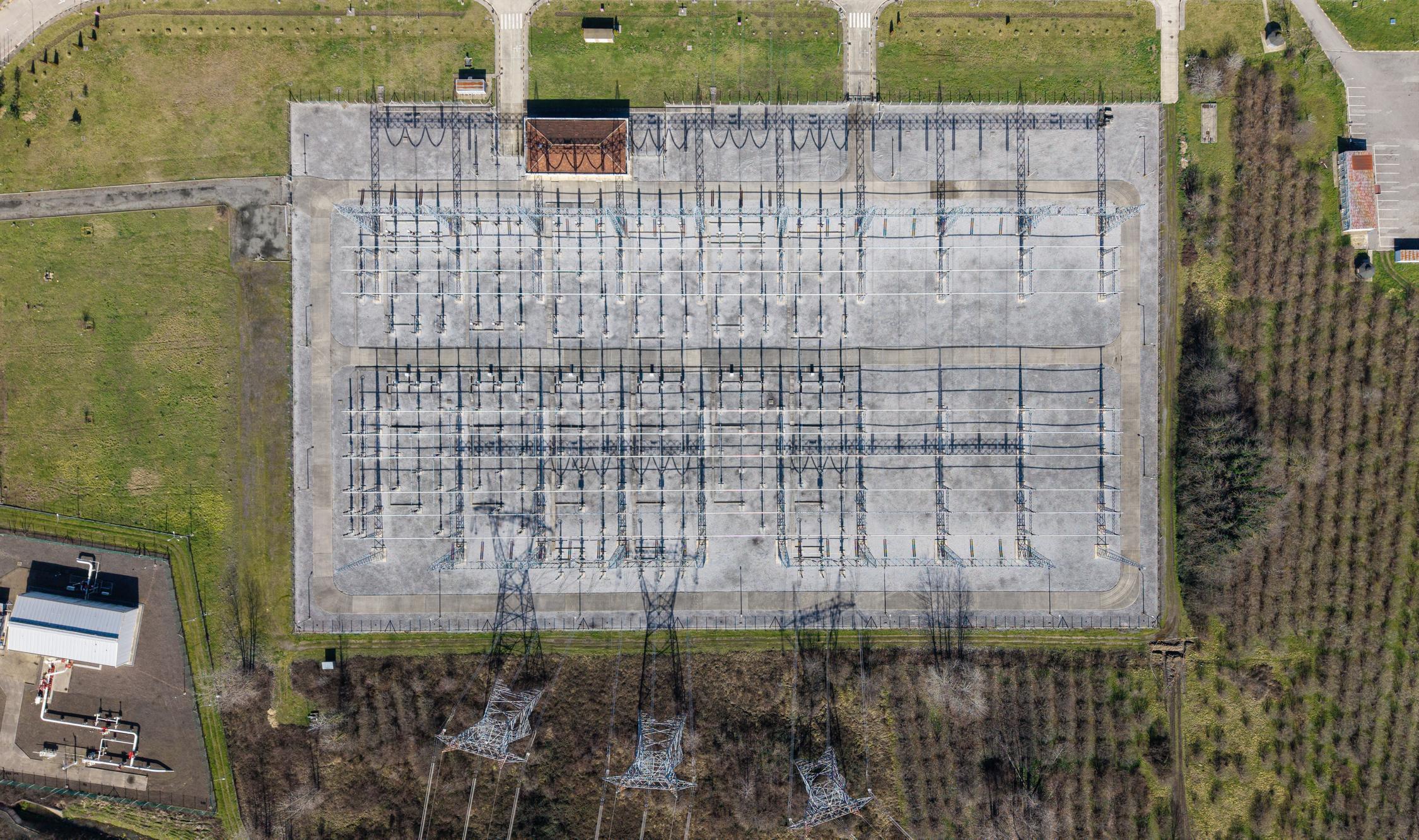 Electrical substation distributing electricity through a vast power grid, captured from an aerial perspective